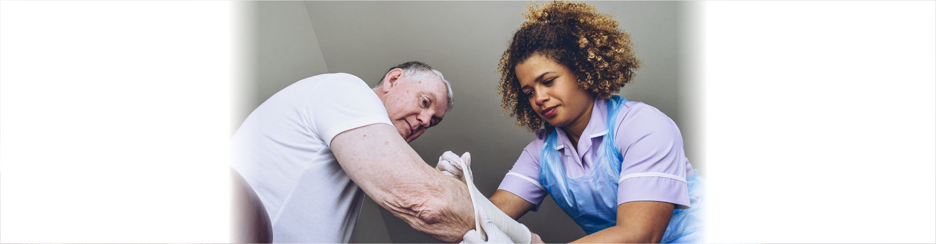 caregiver putting bandage on senior man