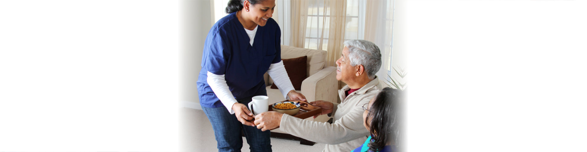 caregiver serving food to elderly couple