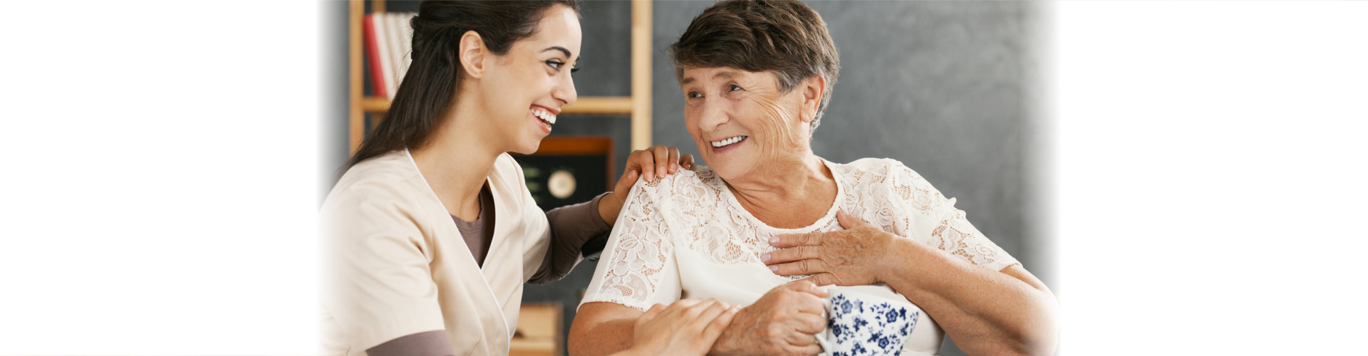 caregiver smiling at an elderly woman